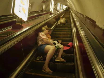 A mother with her daughter sleeps on the stairs of a metro station as they take cover during a Russian attack on Kyiv, Ukraine, on Thursday, July 10, 2025. (AP Photo/Evgeniy Maloletka)