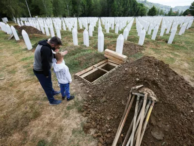 Aljo Mujcic, a Bosnian man, shows his sons a spot dug ahead of a mass funeral marking the 30th anniversary of the Srebrenica genocide, at the Srebrenica-Potocari Memorial Center in Potocari, near Srebrenica, Bosnia and Herzegovina, July 10, 2025. REUTERS/Amel Emric