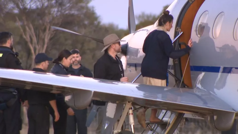 SCREENSHOT - 11 July 2025, Australia, ---: A screenshot from an ABC television video shows Carolina Wilga (R) boarding a plane. A German backpacker who had been missing for 12 days in remote bushland has been found alive by emergency services. Photo: -/ABC via AAP/dpa - ACHTUNG: Nur zur redaktionellen Verwendung und nur mit vollst&auml;ndiger Nennung des vorstehenden Credits