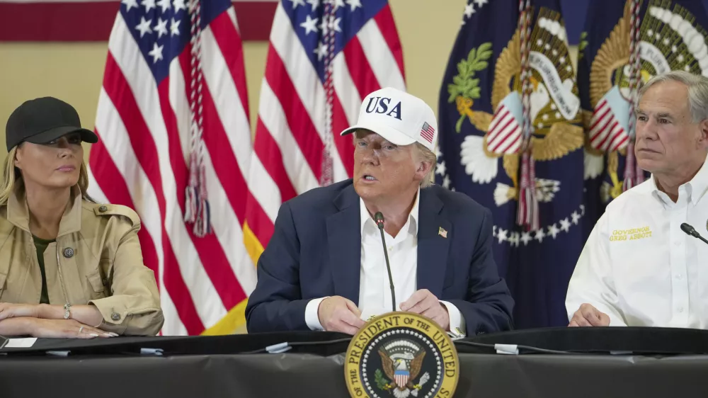 President Donald J. Trump, center, first lady Melania Trump and Texas Gov. Greg Abbott, attend a roundtable discussion at the Community Emergency Operations Center in Kerrville, Texas, Friday, July 11, 2025. (Ricardo B. Brazziell/Austin American-Statesman via AP)