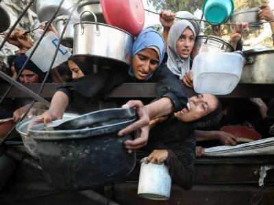 Palestinians react as they ask for food from a charity kitchen, amid a hunger crisis, in Gaza City, July 14, 2025. REUTERS/Mahmoud Issa