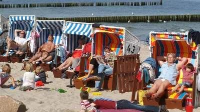 Tourists sit in beach chairs as they enjoy the warm weather and bright sunshine at the Baltic Sea resort of Kuehlungsborn, northern Germany, Sunday, April 15, 2007. (AP Photo/Thomas Haentzschel)