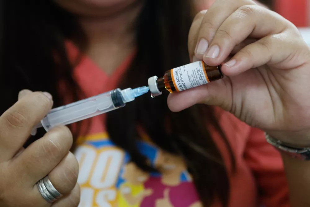 A volunteer health worker prepares to administer a vaccine to a child at a health centre in the city of Taguig in the metropolitan area of Manila, Philippines. UNICEF is working with the Philippine government to improve routine immunization coverage in the country, which is only at 55 percent nationally. The Philippines is one of the ten countries that accounted for more than a 74 percent increase in measles cases between 2017 and 2018 globally.The Department of Health declared measles outbreaks across the country in February 2019. In response to this, UNICEF is working closely with the Department of Health and providing technical assistance to support the Philippine government's campaign to vaccinate 9 million children across 17 regions in the country.