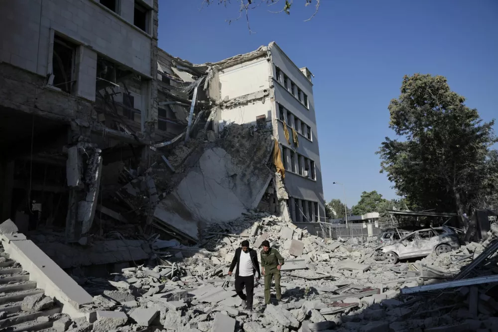 Men walk among debris, after powerful airstrikes shook Damascus on Wednesday, targeting the defense ministry, as Israel vowed to destroy Syrian government forces attacking Druze communities in southern Syria and demanded their withdrawal, in Damascus July 16, 2025. REUTERS/Khalil Ashawi