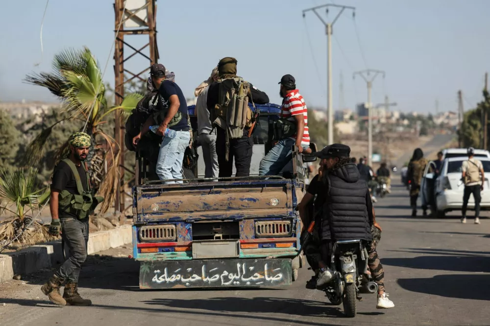 Bedouin fighters stand in the back of a truck at an Internal Security Forces checkpoint working to prevent Bedouin fighters from advancing towards Sweida, following renewed fighting between Bedouin fighters and Druze gunmen, despite an announced truce, in Walgha, Sweida province, Syria July 19, 2025. REUTERS/Khalil Ashawi
