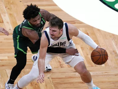 Dallas Mavericks guard Luka Doncic, right, is pressured by Boston Celtics guard Marcus Smart during the second half of an NBA basketball game Wednesday, March 31, 2021, in Boston. (AP Photo/Charles Krupa)