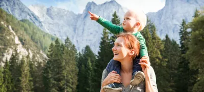 Srečna mamica z otročičkom med lepimi gorami.