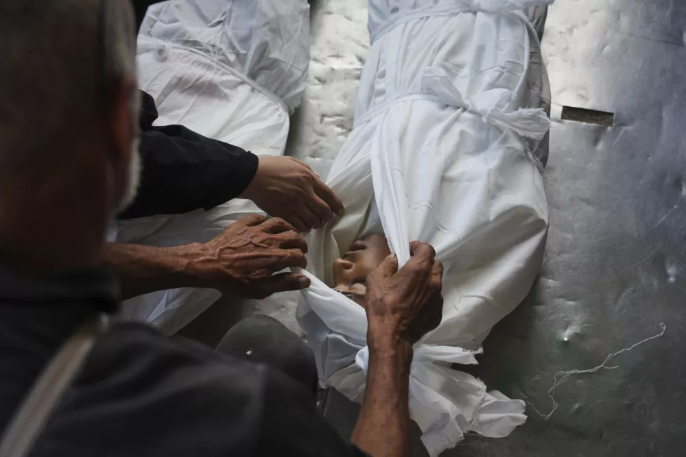 Relatives look at the body of Palestinian child Abdullah al-Rantisi, 11, killed by an Israeli military bombardment, in Deir al-Balah, central Gaza Strip, Monday, July 21, 2025. (AP Photo/Abdel Kareem Hana)