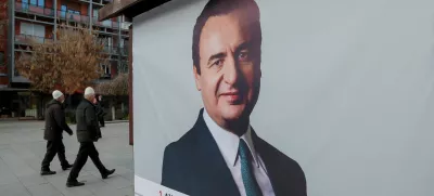 Pedestrians walk near a campaign poster for the upcoming parliamentary elections showing a portrait of Albin Kurti, Kosovo's Prime Minister and leader of the Self-Determination party, in Pristina, Kosovo February 4, 2025. REUTERS/Valdrin Xhemaj