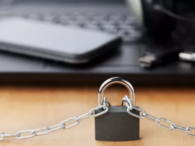 Chain with lock in front of the laptop and smartphone, gadget and digital devices detox concept / Foto: Julia_sudnitskaya