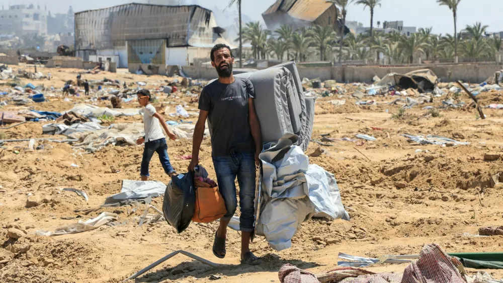A displaced Palestinian walks in the aftermath of an Israeli military operation in Deir Al-Balah, in the central Gaza Strip, July 22, 2025. REUTERS/Hatem Khaled   TPX IMAGES OF THE DAY
