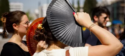 23 July 2025, Greece, Athen: Tourists stand in front of the Greek parliament in the center of Athens. A heatwave with temperatures of over 40 degrees is making life difficult for people in large parts of Greece. Photo: Socrates Baltagiannis/dpa