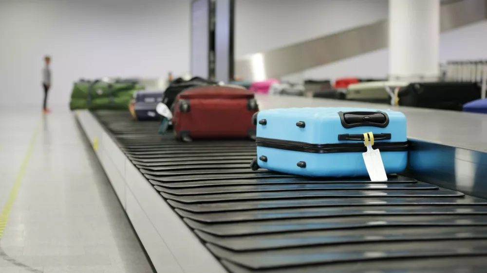 Suitcase or luggage on conveyor belt in the airport waiting