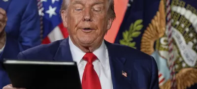 President Donald Trump signs executive orders after speaking during an AI summit at the Andrew W. Mellon Auditorium, Wednesday, July 23, 2025, in Washington. (AP Photo/Julia Demaree Nikhinson)