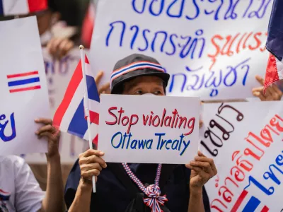 Bangkok, 20 July 2025 &ndash; A protester holds a sign reading "Stop violating Ottawa Treaty" during a nationalist demonstration outside the Cambodian Embassy in Bangkok. Protesters gathered outside the Royal Embassy of Cambodia to denounce Cambodia's alleged use of landmines on Thai territory, following the injury of Thai soldiers near the Chong Bok border area. Authorities claim the mines, recently discovered beyond Cambodia's military line, violate the Ottawa Convention.Bangkok, 20 juillet 2025 &ndash; Une manifestante brandit une pancarte &laquo; Stop violating Ottawa Treaty &raquo; lors d'un rassemblement nationaliste devant l'ambassade du Cambodge a Bangkok. Des manifestants se sont rassembles devant l'Ambassade Royale du Cambodge pour denoncer l'usage presume de mines antipersonnel par le Cambodge sur le territoire thailandais, apres la blessure de soldats thailandais pres de la frontiere de Chong Bok. Les autorites affirment que les mines, recemment decouvertes au-dela de la ligne militaire cambodgienne, enfreignent la Convention d'Ottawa.