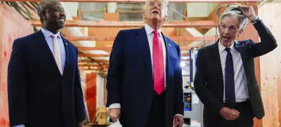 Federal Reserve Chairman Jerome Powell, right, takes off his hard hat as President Donald Trump, center, and Sen. Tim Scott, R-S.C., look at ongoing construction at the Federal Reserve, Thursday, July 24, 2025, in Washington. (AP Photo/Julia Demaree Nikhinson)