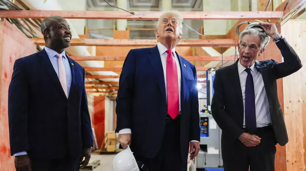 Federal Reserve Chairman Jerome Powell, right, takes off his hard hat as President Donald Trump, center, and Sen. Tim Scott, R-S.C., look at ongoing construction at the Federal Reserve, Thursday, July 24, 2025, in Washington. (AP Photo/Julia Demaree Nikhinson)