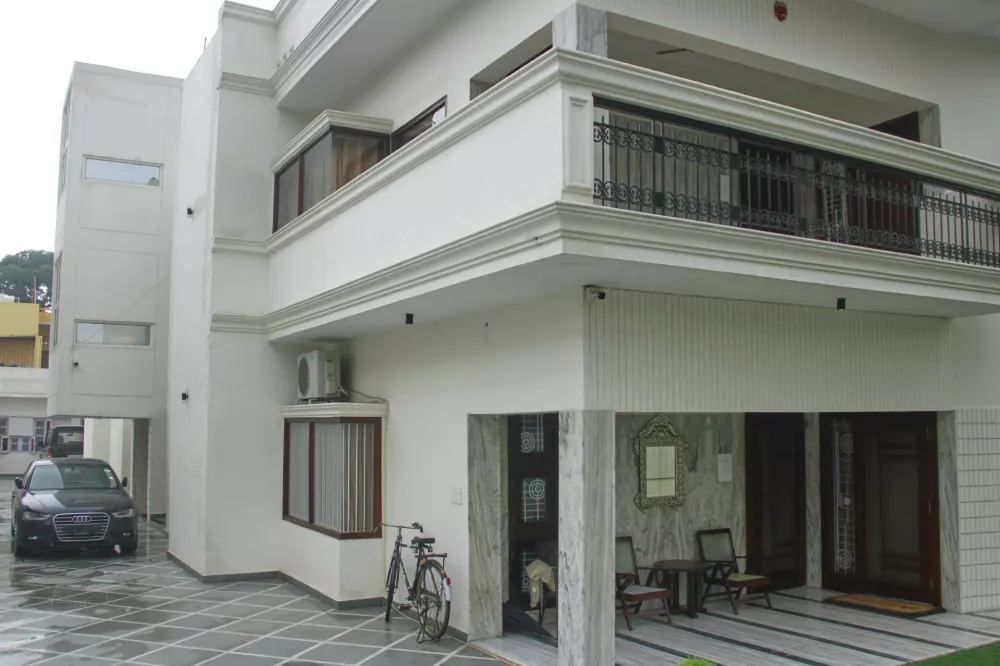 A luxury car and a bicycle are seen parked outside a rented residential building in which a bogus embassy was running in Ghaziabad, outskirts of New Delhi, India, Wednesday, July 23, 2025. (AP Photo)