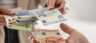 denar, plača, evro, evri, gotovina Businesswoman's hands exchanging euro banknotes, closeup shot. / Foto: Marianvejcik