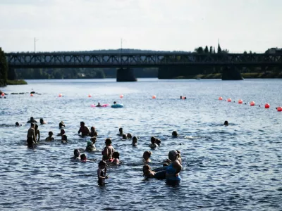People enjoy the warm weather at the Ounaskoski Beach in Rovaniemi, Finland, July 23, 2025.  Lehtikuva/Jouni Porsanger/via REUTERS   ATTENTION EDITORS - THIS IMAGE WAS PROVIDED BY A THIRD PARTY. NO THIRD PARTY SALES. NOT FOR USE BY REUTERS THIRD PARTY DISTRIBUTORS. FINLAND OUT. NO COMMERCIAL OR EDITORIAL SALES IN FINLAND.