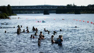 People enjoy the warm weather at the Ounaskoski Beach in Rovaniemi, Finland, July 23, 2025.  Lehtikuva/Jouni Porsanger/via REUTERS   ATTENTION EDITORS - THIS IMAGE WAS PROVIDED BY A THIRD PARTY. NO THIRD PARTY SALES. NOT FOR USE BY REUTERS THIRD PARTY DISTRIBUTORS. FINLAND OUT. NO COMMERCIAL OR EDITORIAL SALES IN FINLAND.
