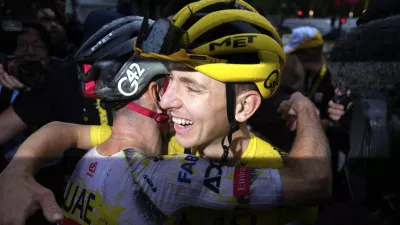 Tour de France winner Tadej Pogacar of Slovenia is hugged by a teammate after the twenty-first stage of the Tour de France cycling race over 132.3 kilometers (82.1 miles) with start in Mantes-la-Ville and finish on the Champs-Elysees in Paris, France, Sunday, July 27, 2025. (AP Photo/Mosa'ab Elshamy)