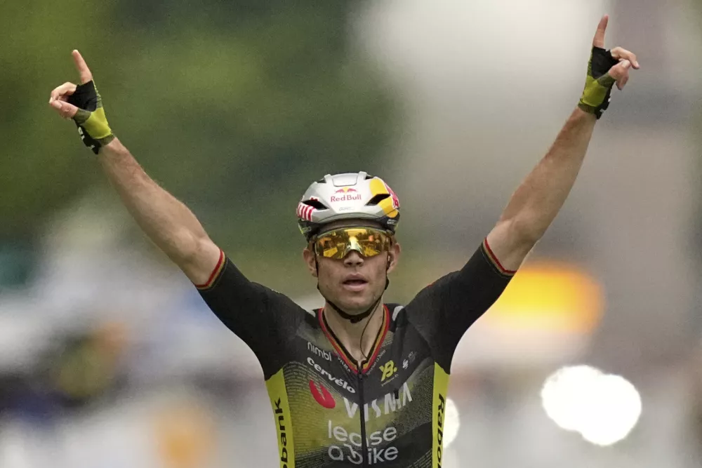 Belgium's Wout van Aert crosses the finish line to win the twenty-first stage of the Tour de France cycling race over 132.3 kilometers (82.1 miles) with start in Mantes-la-Ville and finish on the Champs-Elysees in Paris, France, Sunday, July 27, 2025. (AP Photo/Thibault Camus)