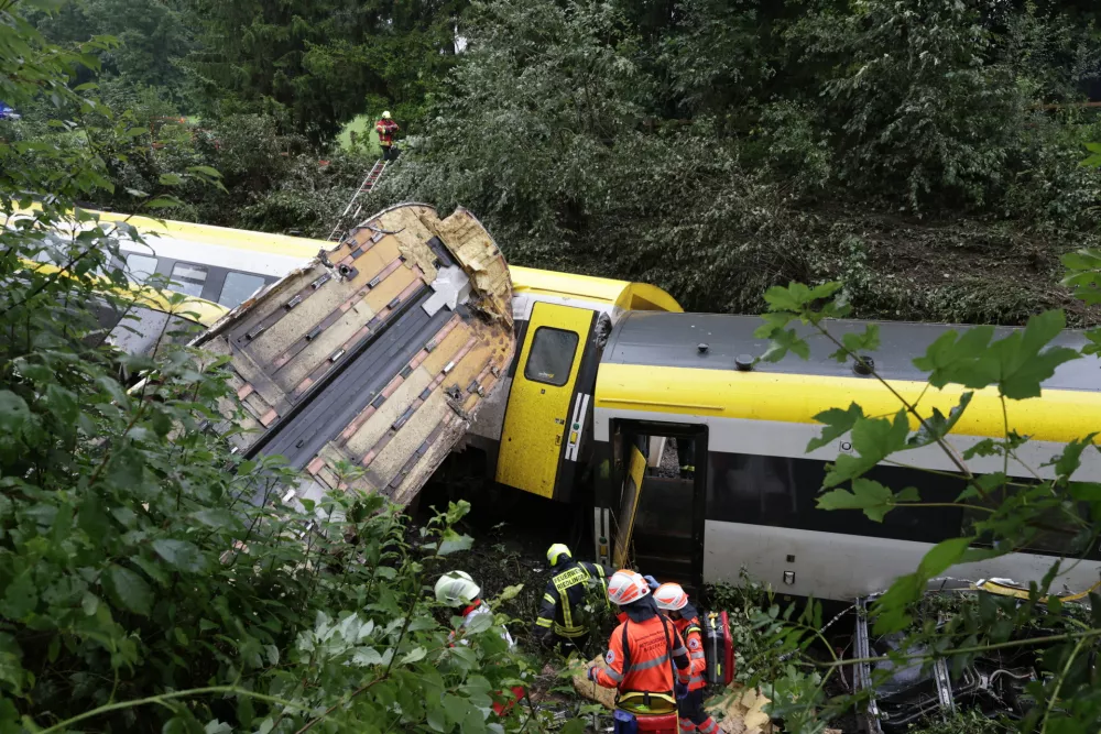 27 July 2025, Riedlingen: Rescue workers search for passengers in a derailed train. Several people have been killed and many others injured after a passenger train derailed in Biberach district between Zweifaltendorf and Zell in south-western Germany. Photo: Thomas Warnack/dpa