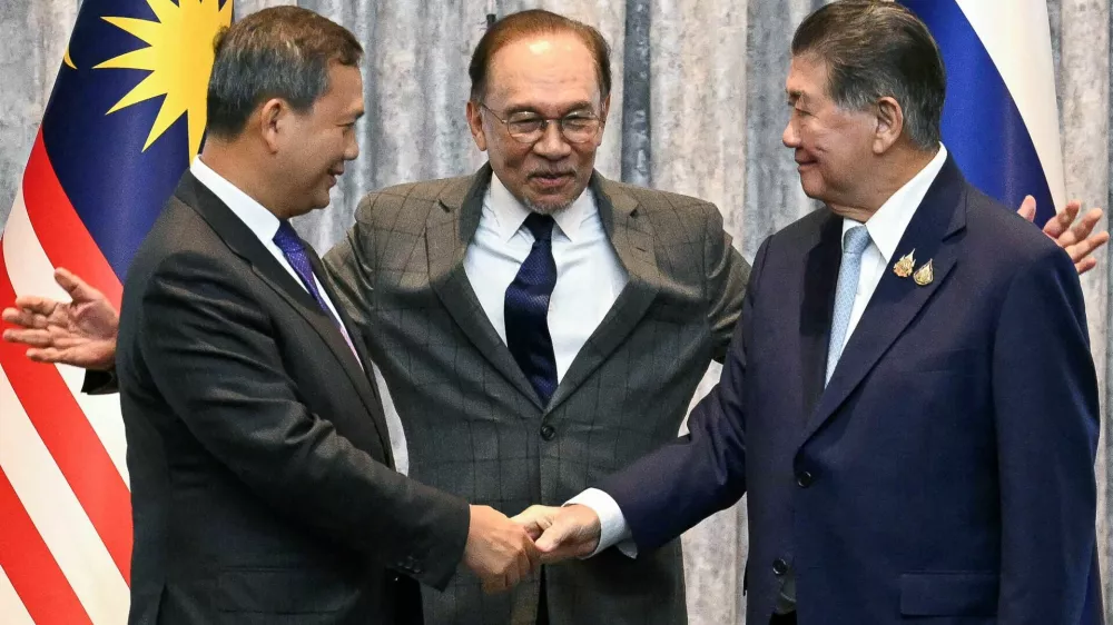 Malaysia's Prime Minister Anwar Ibrahim reacts as Cambodia's Prime Minister Hun Manet and Thailand's acting Prime Minister Phumtham Wechayachai shake hands following a press conference, on the day of mediation talks on the Thailand&ndash;Cambodia border conflict, in Putrajaya, Malaysia July 28, 2025.  Mohd Rasfan/Pool via REUTERS