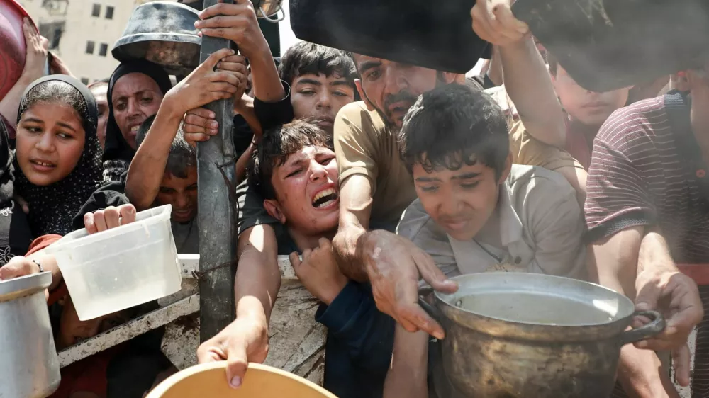 Palestinians wait to receive food from a charity kitchen, amid a hunger crisis, in Gaza City, July 28, 2025. REUTERS/Khamis Al-Rifi