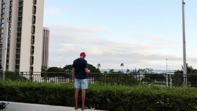 A man stands on a ledge at a shopping center looking for tsunami waves, after authorities warned residents of the possibility of destructive tsunami waves, following an earthquake which earlier struck off Russia's Far Eastern Kamchatka Peninsula, in Honolulu, Hawaii, U.S. July 29, 2025.  REUTERS/Marco Garcia