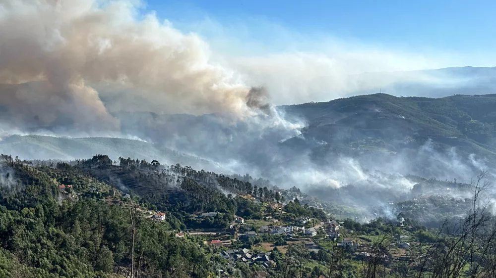 Smoke from a wildfire rises over the hills near the village of Canelas, Arouca region, Portugal, July 29, 2025. REUTERS/Miguel Pereira