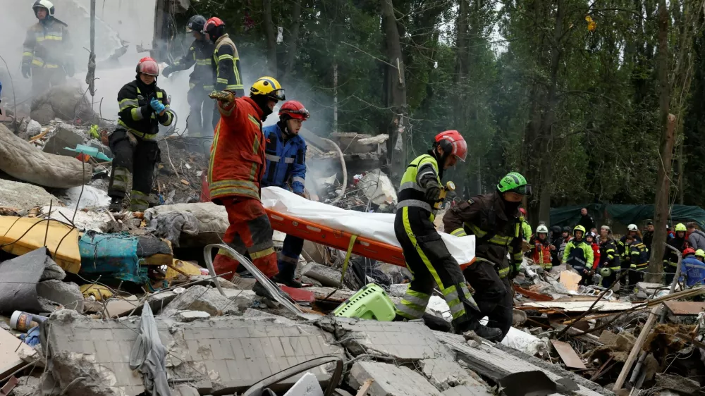 Rescuers carry a body at the site of an apartment building hit during Russian missile and drone strikes, amid Russia's attack on Ukraine, in Kyiv, Ukraine July 31, 2025. REUTERS/Thomas Peter