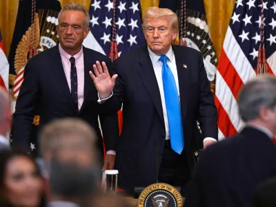 President Donald Trump and Health and Human Service Secretary Robert F. Kennedy, Jr., left, depart after speaking at an event in the East Room of the White House, Wednesday, July 30, 2025, in Washington. (AP Photo/John McDonnell)