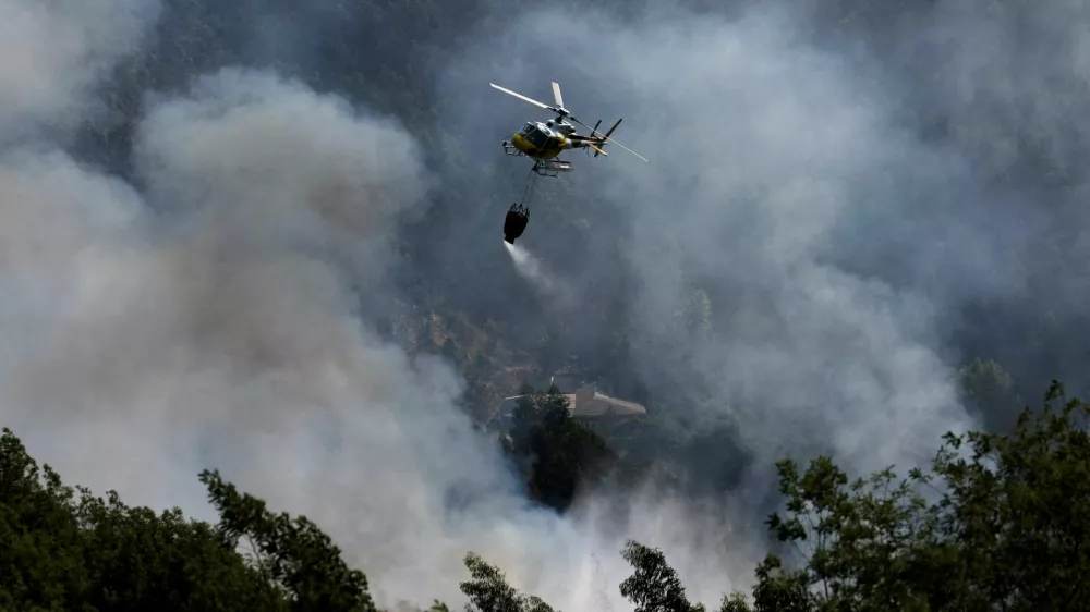 A helicopter flies after unloading water during efforts to battle a wildfire in the Arouca region, Portugal, July 30, 2025. REUTERS/Violeta Santos Moura   TPX IMAGES OF THE DAY