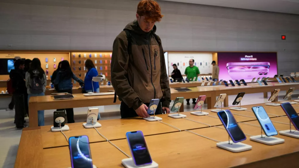 FILE PHOTO: A person looks at iPhones in the Apple Fifth Avenue store in New York City, U.S., May 23, 2025. REUTERS/Adam Gray/File Photo