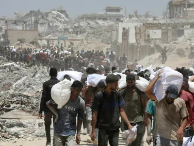 Palestinians carry aid supplies that entered Gaza through Israel, in Beit Lahia in the northern Gaza Strip, August 1, 2025. REUTERS/Dawoud Abu Alkas