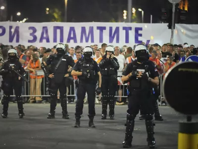 Riot police take positions between government supporters, seen in the background, and people taking part in a major anti-government rally pressing for an early election after nearly eight months of almost daily anti-corruption demonstrations that have shaken the populist government of President Aleksandar Vucic, in Belgrade, Serbia, Saturday, June 28, 2025. (AP Photo/Darko Vojinovic)