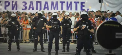 Riot police take positions between government supporters, seen in the background, and people taking part in a major anti-government rally pressing for an early election after nearly eight months of almost daily anti-corruption demonstrations that have shaken the populist government of President Aleksandar Vucic, in Belgrade, Serbia, Saturday, June 28, 2025. (AP Photo/Darko Vojinovic)
