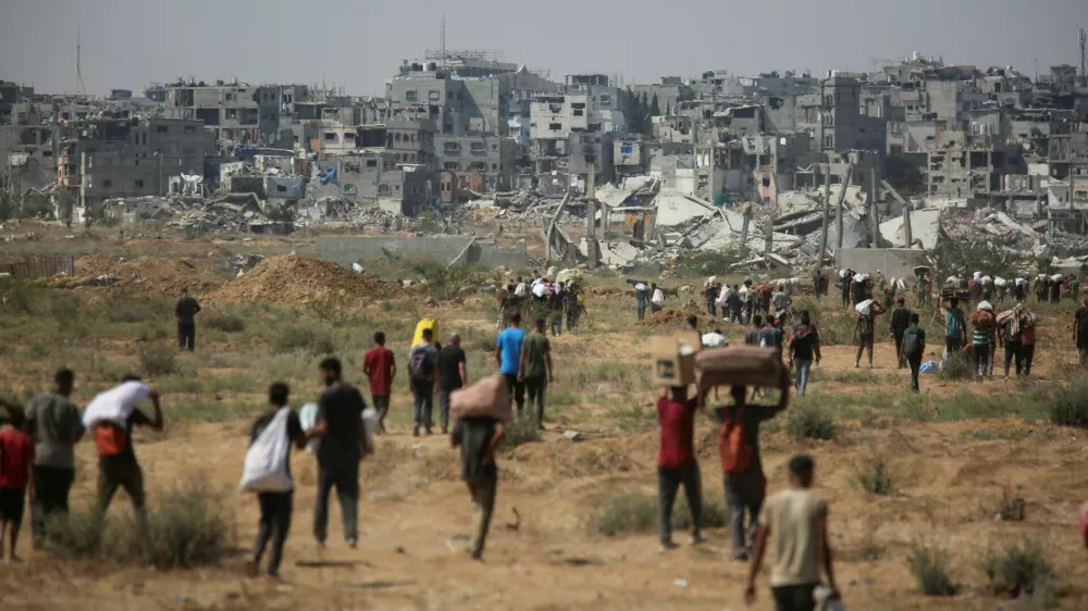 Palestinians carry aid supplies which they received from the U.S.-backed Gaza Humanitarian Foundation (GHF), in the central Gaza Strip, August 4, 2025. REUTERS/Stringer