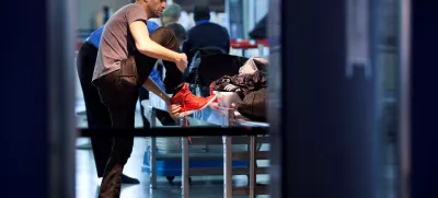 FILE PHOTO: A traveler removes his shoes before going through a security check point at John F. Kennedy Airport in New York, February, 29, 2012.  REUTERS/Andrew Burton/File Photo