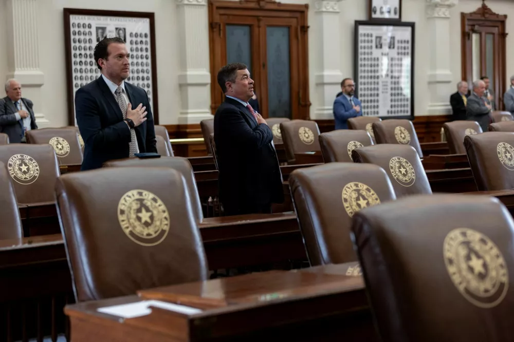 Surrounded by empty seats, Texas lawmakers say the pledge as the House is called to order, after Democratic lawmakers in Texas left the state to deny Republicans the quorum needed to redraw the state's 38 congressional districts, at the Texas State Capitol in Austin, Texas, U.S. August 4, 2025. The session was adjourned shortly due to the lack of quorum. REUTERS/Nuri Vallbona