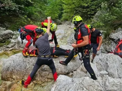 Gorski re&scaron;evalci iz Bovca pomagajo ponesrečenki pri raftingu. 