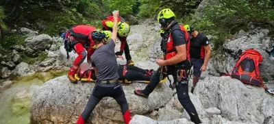 Gorski reševalci iz Bovca pomagajo ponesrečenki pri raftingu. 