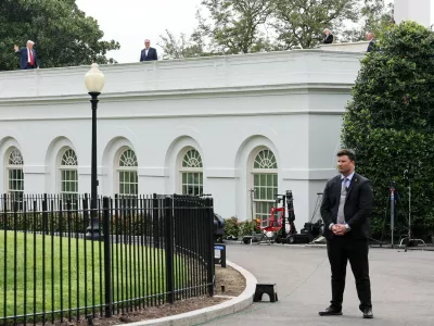 U.S. President Donald Trump waves from the roof as he gets a different view of the site of the proposed ballroom, at the White House in Washington, D.C., U.S., August 5, 2025. REUTERS/Jessica Koscielniak   TPX IMAGES OF THE DAY