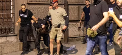 Serbian police officers wearing civilian clothing detain a person, during a standoff between supporters of the ruling party and anti-government protesters in Belgrade, Serbia, August 14, 2025. REUTERS/Djordje Kojadinovic