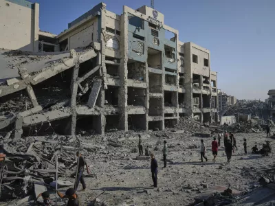 People inspect the damage at the Sheikh Radwan al-Taba UNRWA clinic following an Israeli army bombardment in Gaza City Wednesday, Aug. 6, 2025. The clinic had been evacuated of displaced Palestinians prior to the strike. (AP Photo/Jehad Alshrafi)