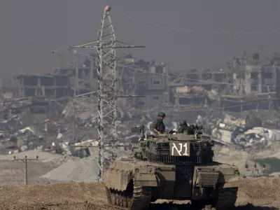 FILE - Israeli soldiers overlook the Gaza Strip from a tank, as seen from southern Israel, on Friday, Jan. 19, 2024. (AP Photo/Maya Alleruzzo, File)