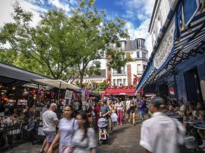 Tourists stroll the Place du Tertre in the Montmartre district in Paris, France, Monday, Aug. 4, 2025. (AP Photo/Aurelien Morissard)
