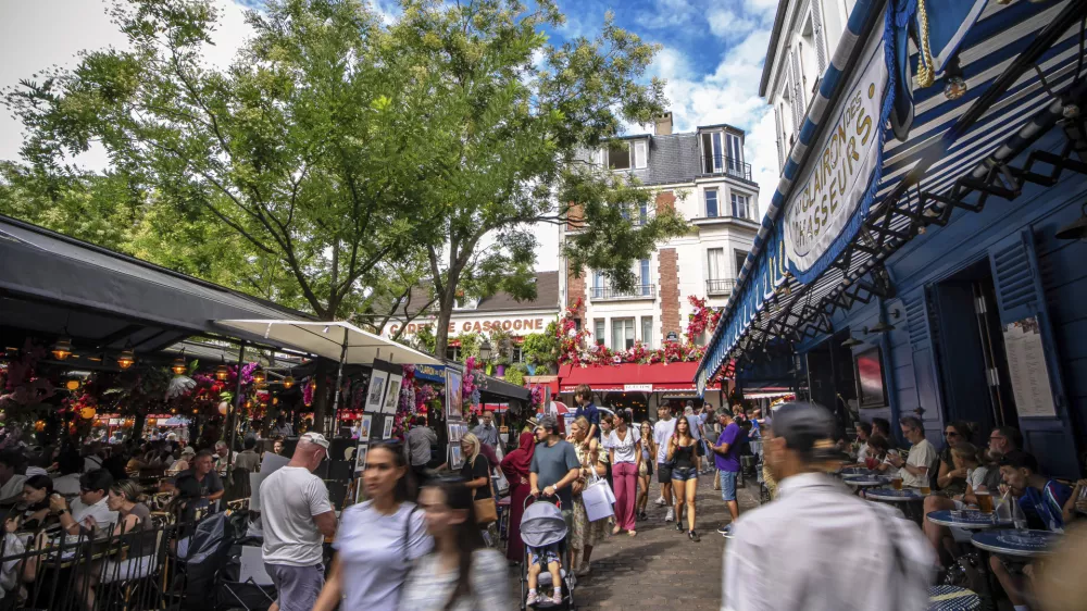 Tourists stroll the Place du Tertre in the Montmartre district in Paris, France, Monday, Aug. 4, 2025. (AP Photo/Aurelien Morissard)